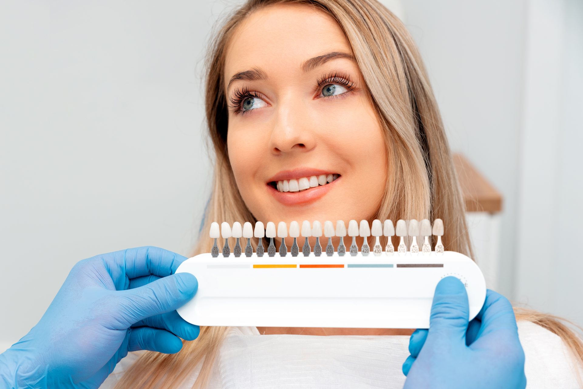 Patient choosing a veneer shade with a shade guide at Dentists of Burleigh